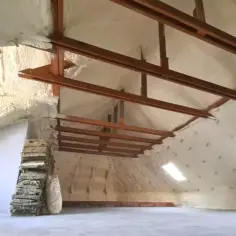 Ocieplenie stropu drewnianego pianką PUR. Widoczne drewniane belki konstrukcyjne i okna dachowe.