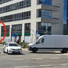 Lustro drogowe poprawia widoczność na drodze wewnętrznej. Obok biały van i samochód taxi.