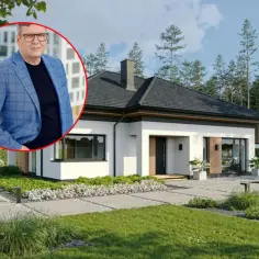 Szacowany koszt budowy domu 150m2 pod klucz. Mężczyzna w garniturze na tle nowoczesnego domu z ogrodem.