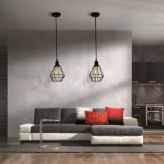 Nowoczesna ściana działowa z betonową fakturą oddziela salon od kuchni. Na niej wiszą dwa industrialne lampy.