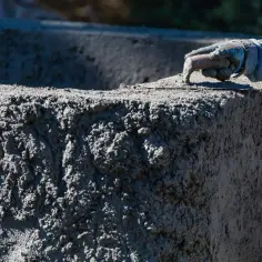 Dłoń w rękawicy wygładza świeży beton. Zastanawiasz się, ile kosztuje gruszka betonu?