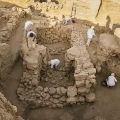 Archeolodzy pracują w starożytnym alkierzu, odsłaniając artefakty i szczątki.