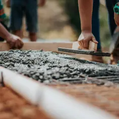 Pracownicy wygładzają świeży beton, co wpływa na jego ostateczną cenę.