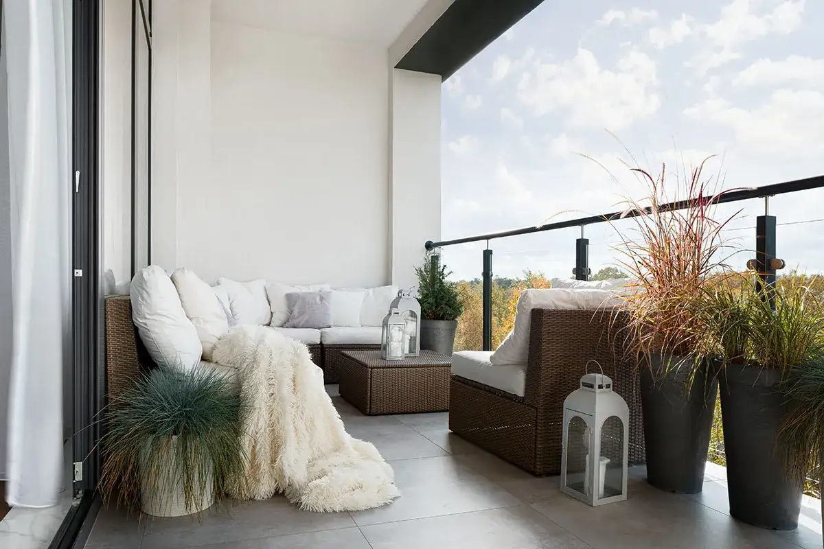 Przytulna loggia z meblami wypoczynkowymi i roślinami. Balkon zaprasza do relaksu na świeżym powietrzu.