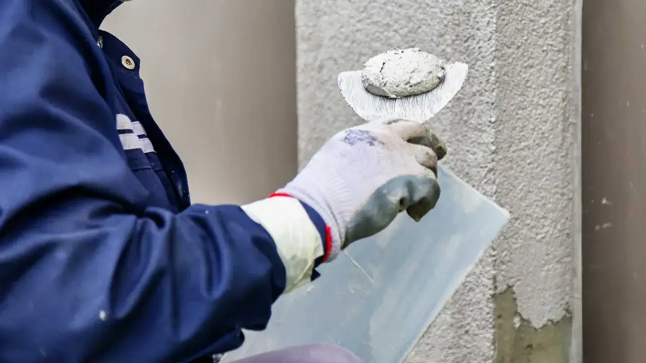 Pracownik nakłada tynk silikonowy. Cena za m2 robocizny zależy od jakości materiału i złożoności prac.